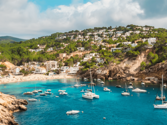 Die Küste von Ibiza ebenfalls eine Sehenswürdigkeit; Blaues wasser, heller sand und boote