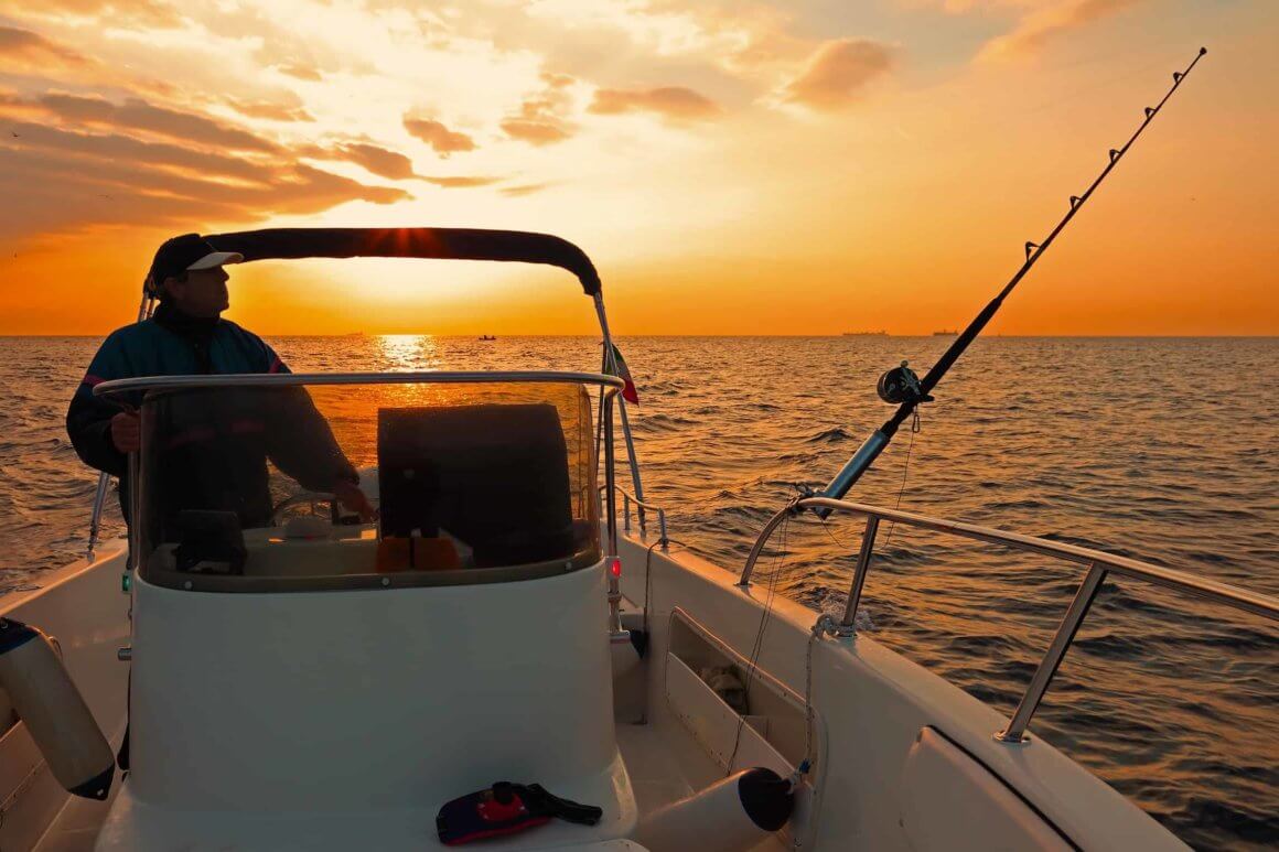 Angeln auf dem Boot bei Sonnenuntergang