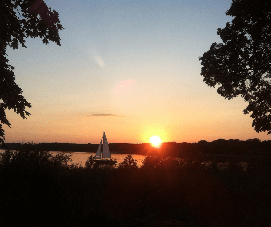 Wannsee bei Sonnenuntergang mit Segelboot auf dem Wasser inmitten der Natur