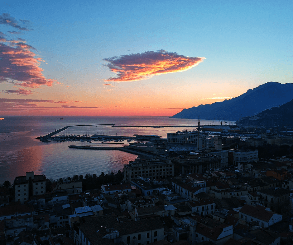 Sonnenuntergang in Salerno mit Blick auf den Hafen und die bergige Küste 