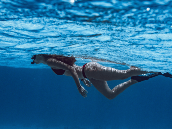 Frau, die im Bikini im blauen Wasser schnorchelt