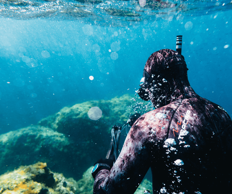 Mensch im schwarzen Neoprenanzug am Schnorcheln Unterwasser