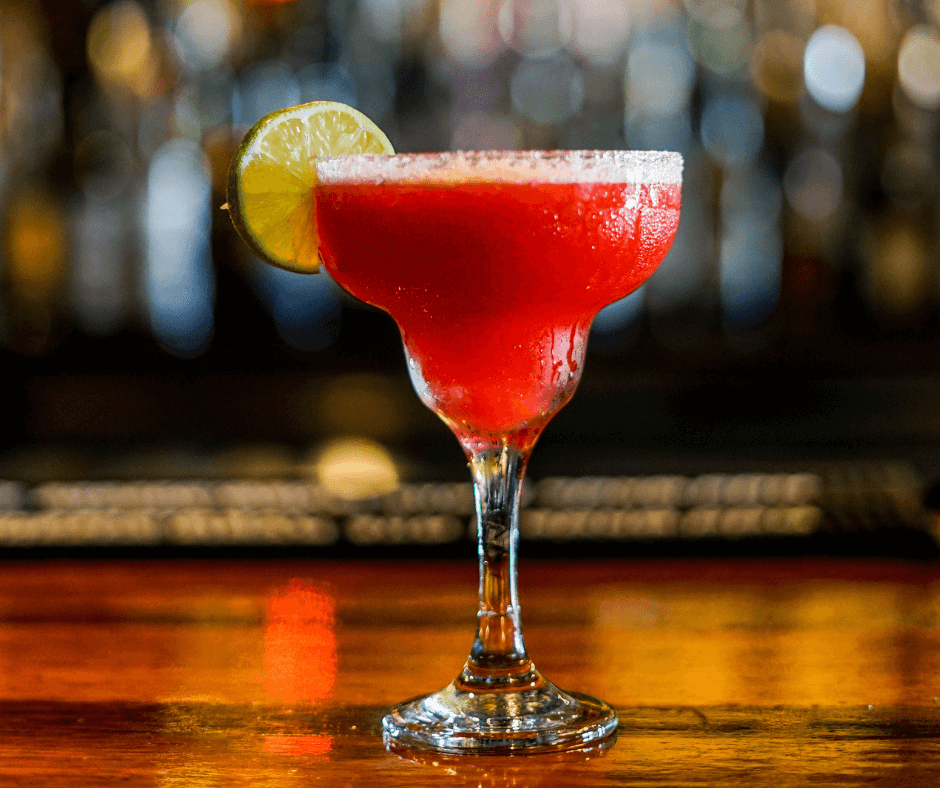 Ein pinker Martini mit Limette am Glas in einer Bar