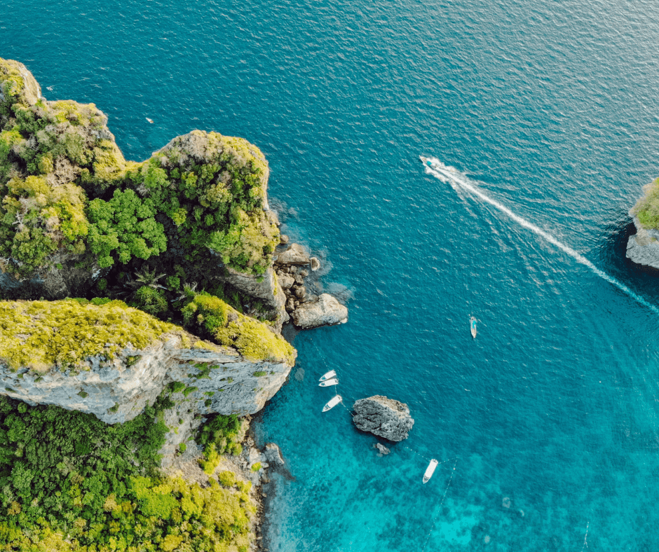 Boot mieten für einen Tag - Ko Phi Phi, Thailand, mehrere Motorboote auf dem türkisfarbenen Wasser, umgeben von grünbewachsenen Felsen