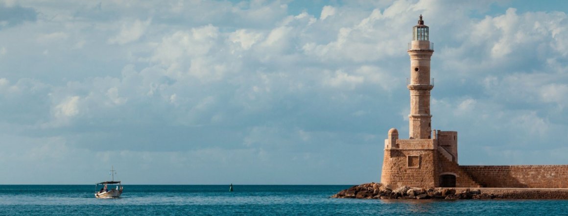 Leuchtturm am Meer mit kleinem Boot