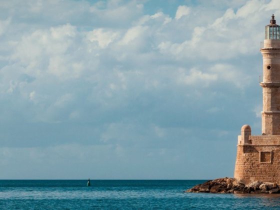 Leuchtturm am Meer mit kleinem Boot