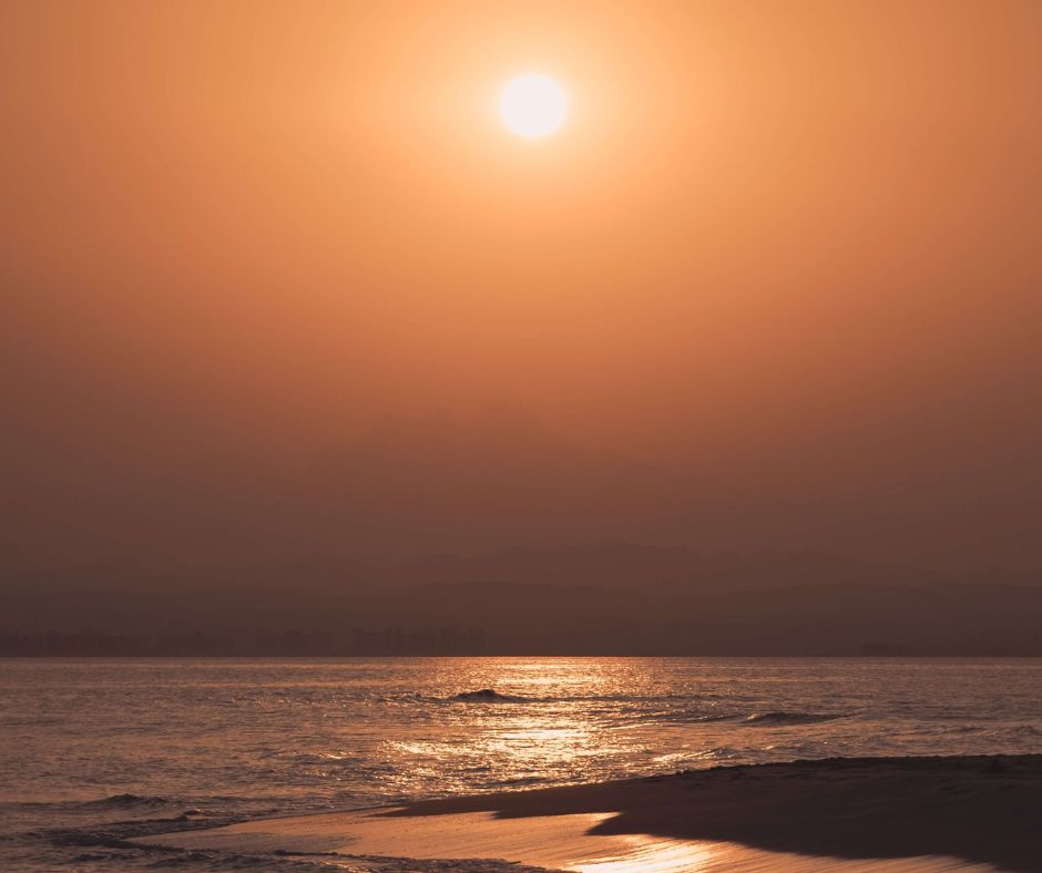 Soma Bay bei tief stehender Sonne, in ein oranges Licht getaucht. Landzunge aus Sand mit viel Meer im Hintergrund.