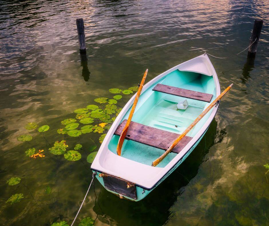 Ein Boot, welches an einem Holzpfahl angebunden ist auf einem See.