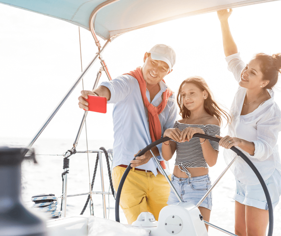 Drei Personen auf einem Segelboot während Ihrem Urlaub an der Costa Brava. Die drei Personen machen ein Selfie auf dem Segelboot.