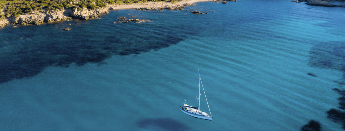 Ein Segelboot auf dem Wasser in Sardinien - entdecken Sie unsere Sardinien Geheimtipps.