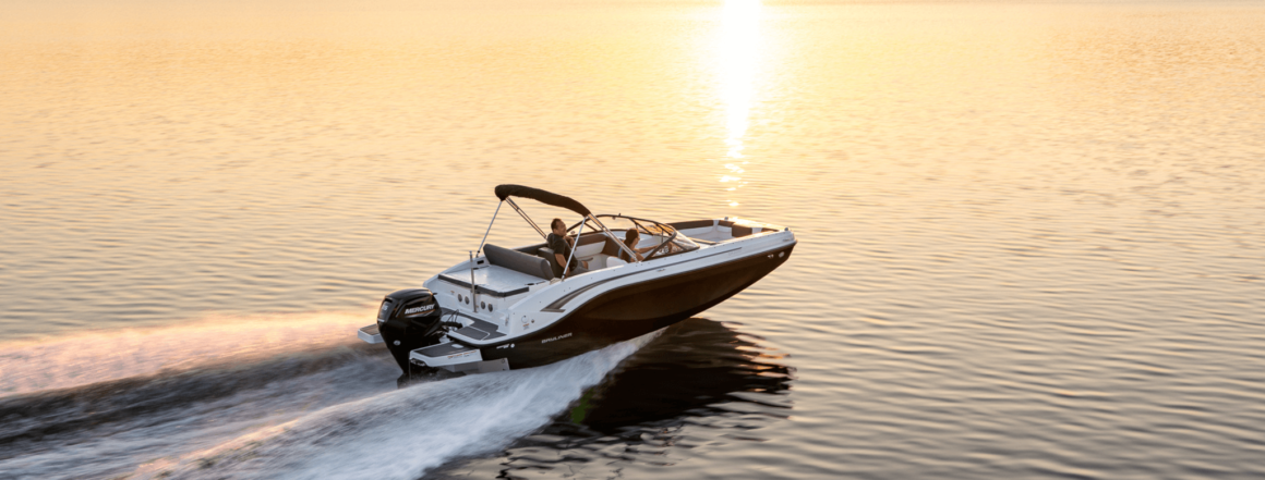 Eine Person fährt ein Motorboot und im Hintergrund ist ein Sonnenuntergang.