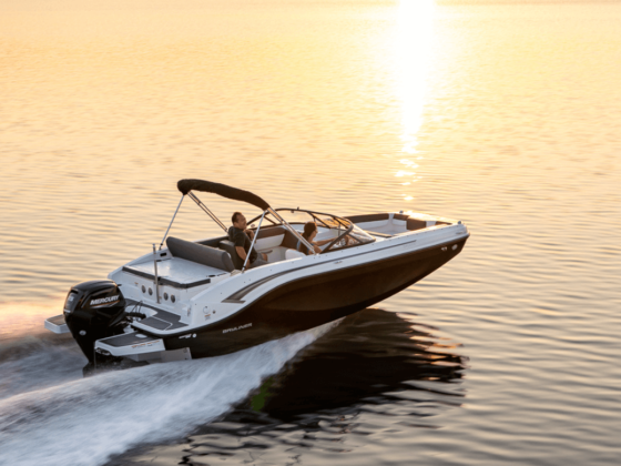 Eine Person fährt ein Motorboot und im Hintergrund ist ein Sonnenuntergang.