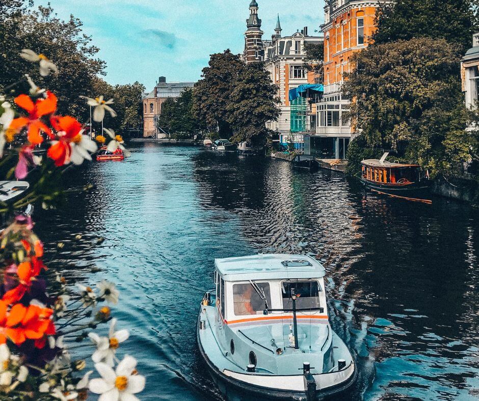 Menschen fahren ein Boot auf dem Wasser in den Kanaälen in Amsterdam.