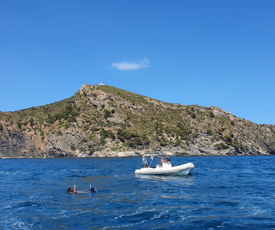 RIB und Schnorchler vor Felsküste der Costa Brava