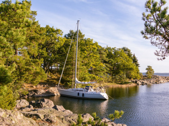 Segelboot ankert an felsiger Küste