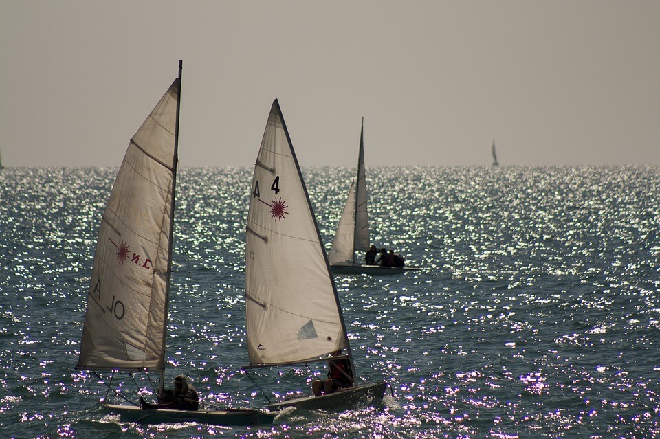 Three sail boats on open waters, peer to peer boat rental 