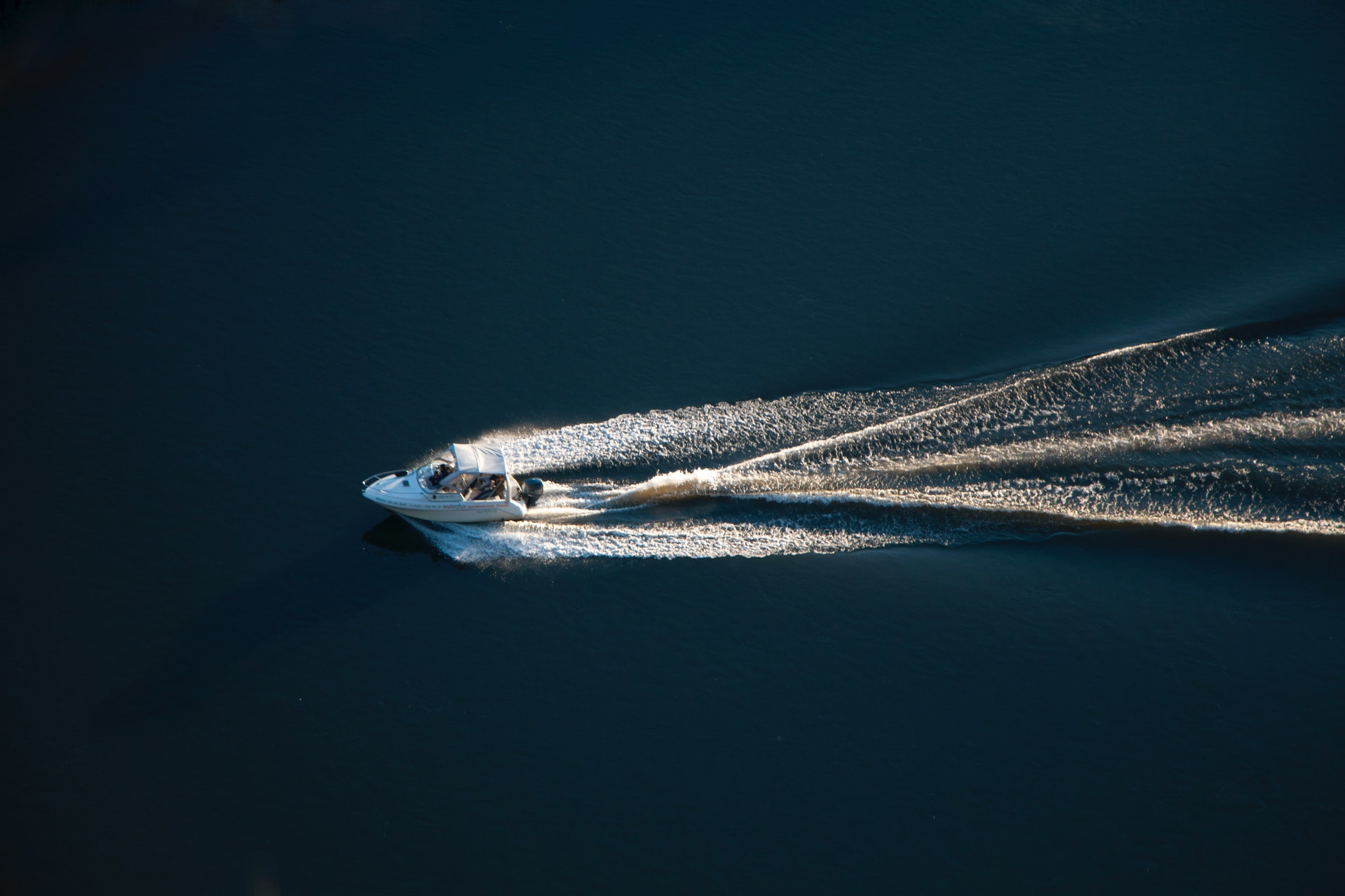 Motorboat cruising on open water in aerial photograph