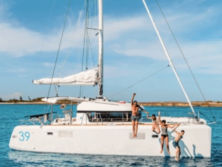 Family on a white sailing catamaran in turquoise water