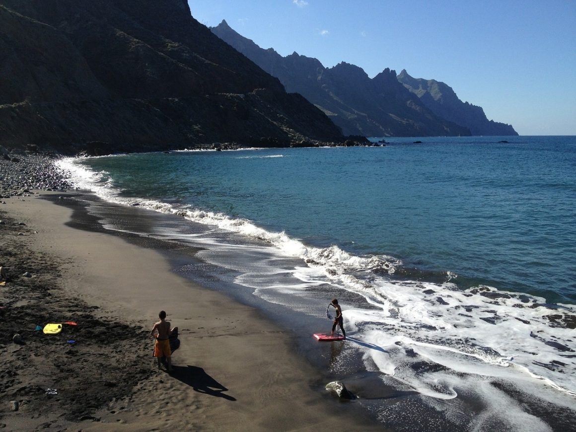 Deep blue sea, black sand, beautiful mountain range