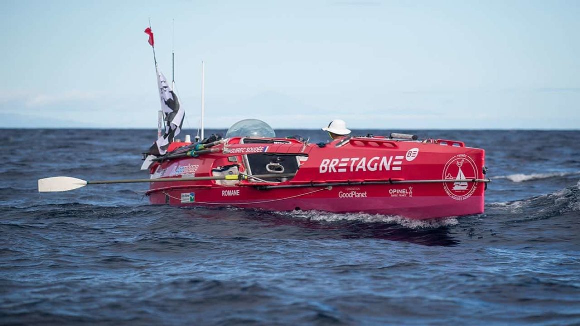 Guirec on his rowing boat across the Atlantic Ocean, with a Breton flag at the bow