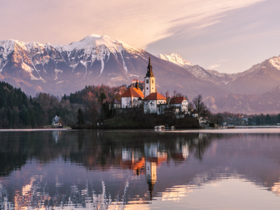 A photo of Lake Bled in Slovenia. A castle in front of large mountains