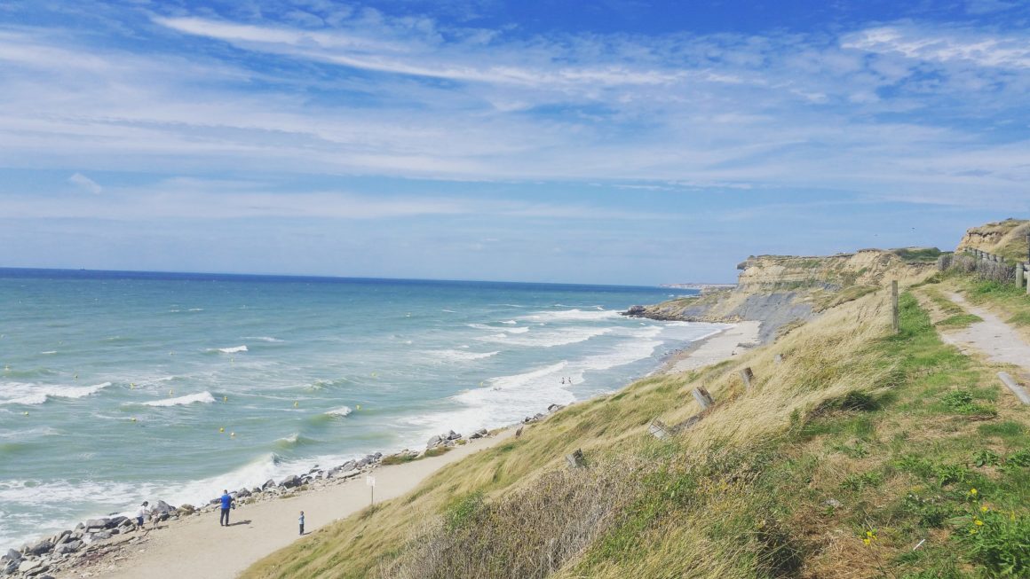 Long, sandy beach in North of France. Rugged coastline and big, crashing waves.