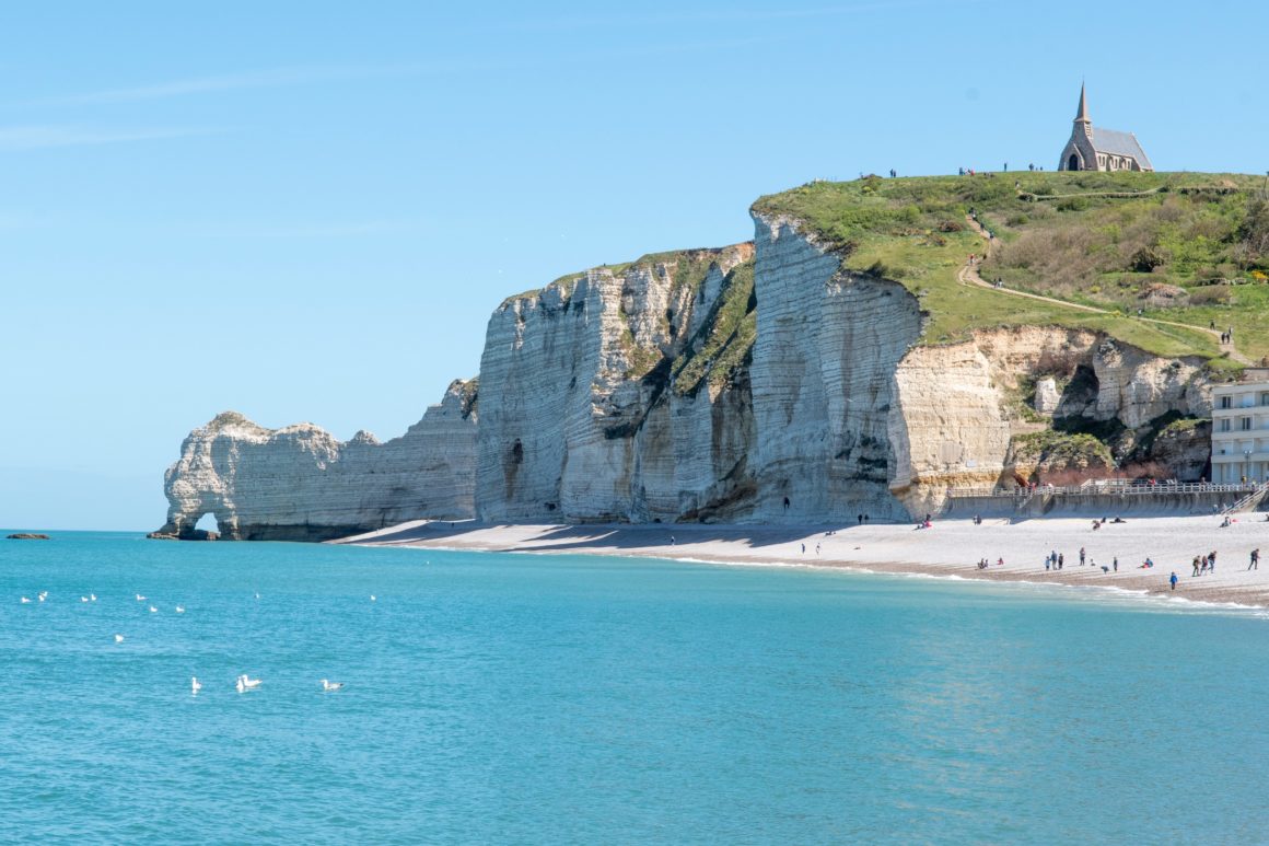 White cliffs of Etretat. Blue skies, pebble beach.