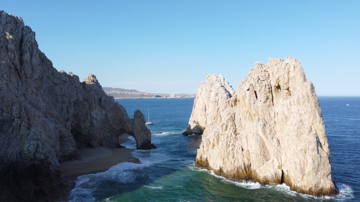 Lover's Beach in Cabo San Lucas, with tall rocks and cliffs along the sea shore.