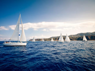 Sailing ship yachts with white sails at the open sea