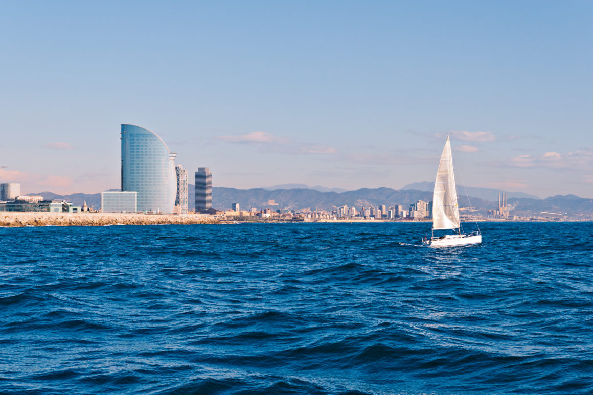 A boat sailing in front of the W hotel in Barcelona