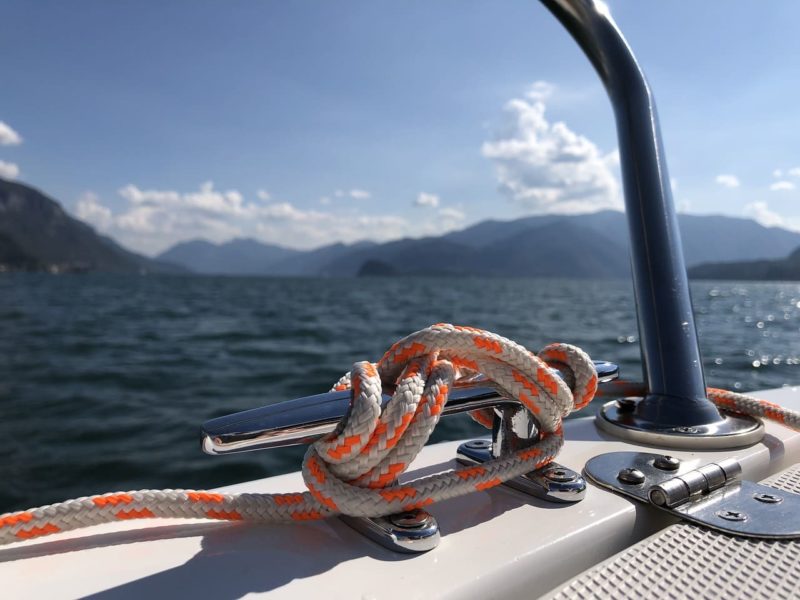 Rope secured to a metal cleat on a small boat at sea