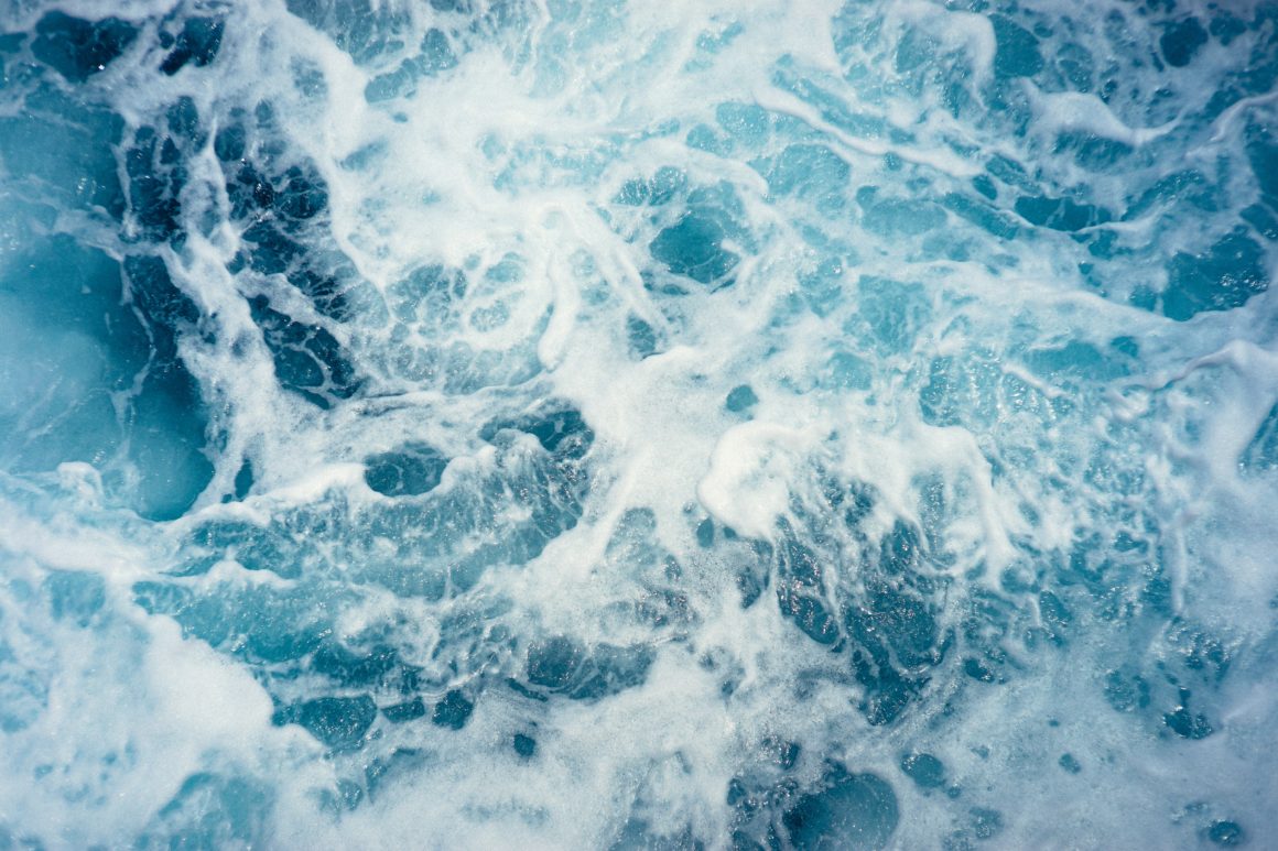 Blue water swirling, with white foam from waves 