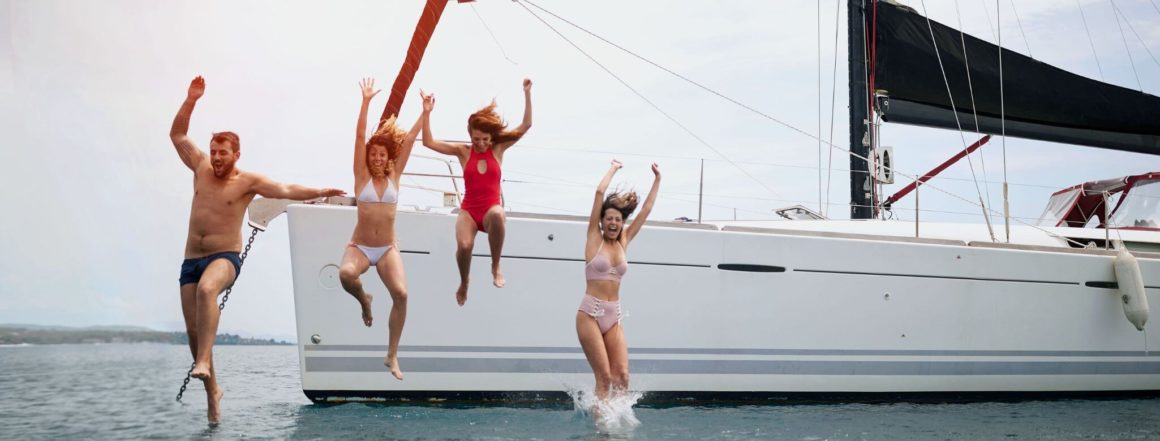sailing holiday - family jumping off a catamaran