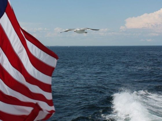 US flag with the ocean behind