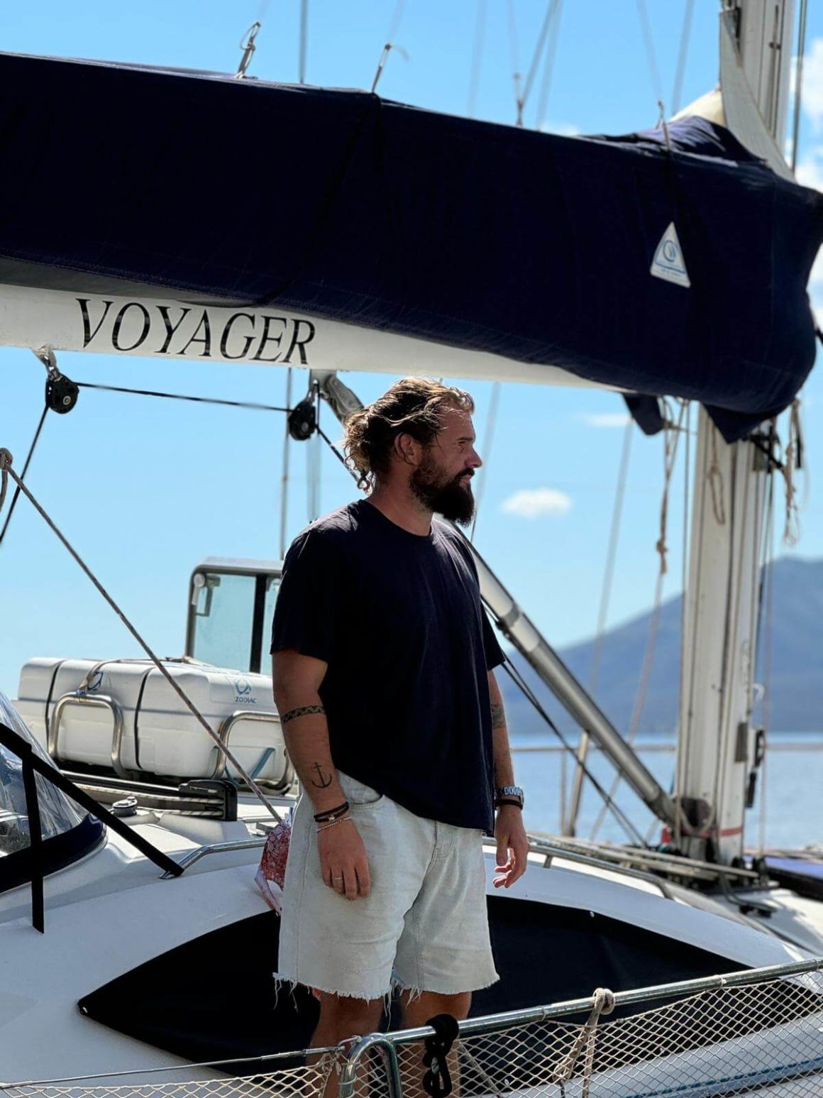 Andrew looking into the distance while standing on his sailboat, a restored 54-foot Jeanneau Sun Odyssey (54DS)