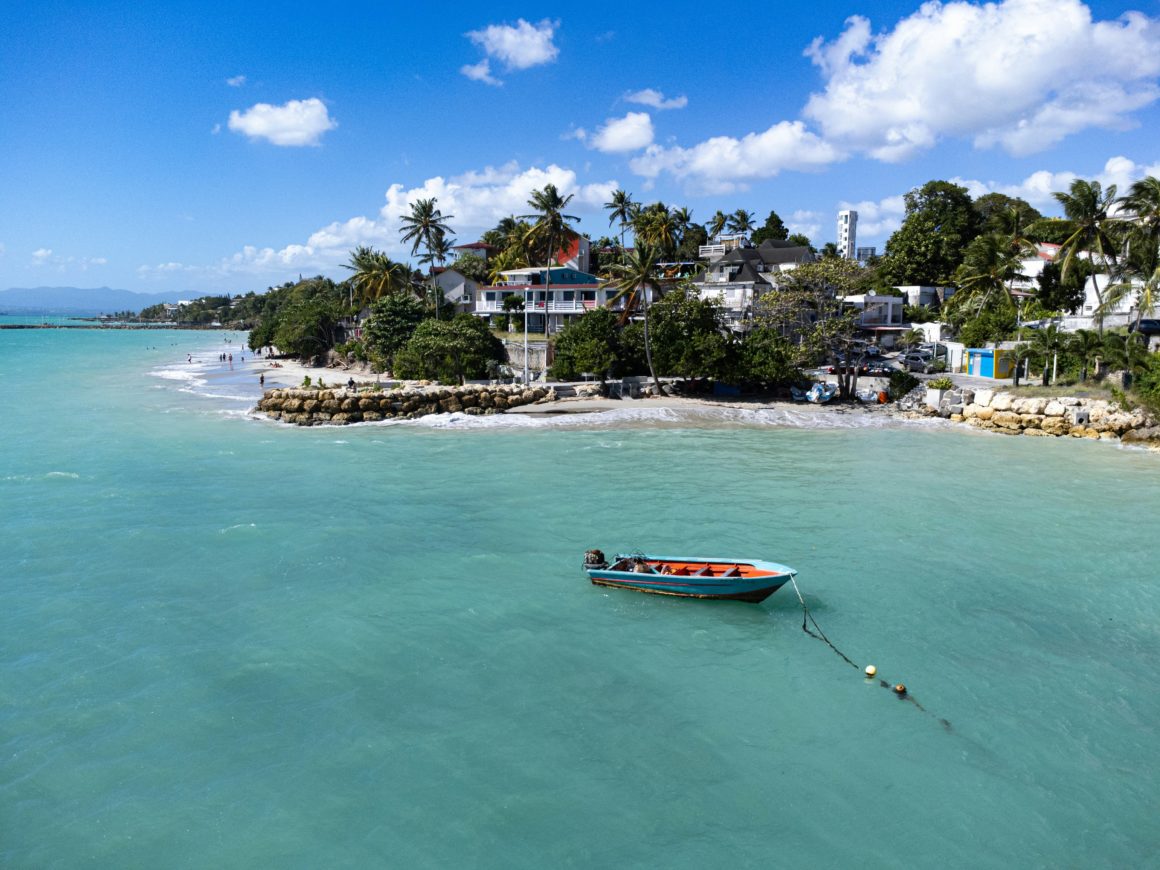 Small fishing boat anchored off a Caribbean village beach