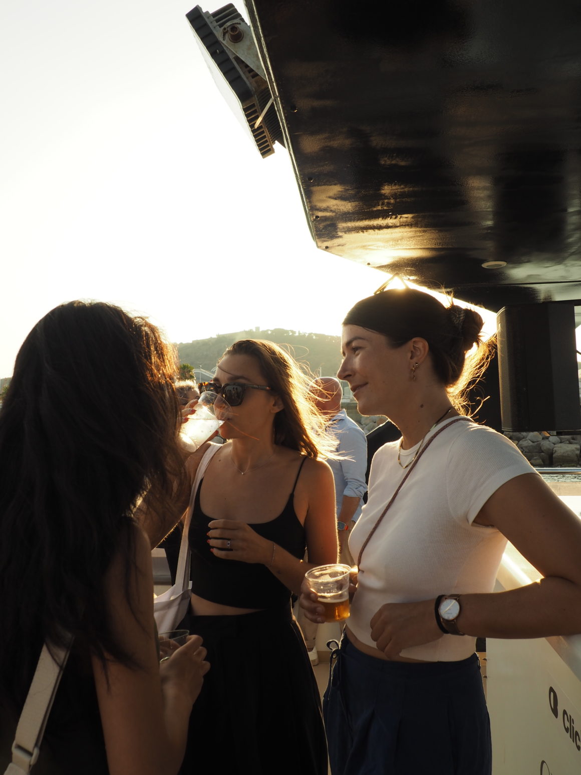 Friends chatting and drinking on a boat at sunset