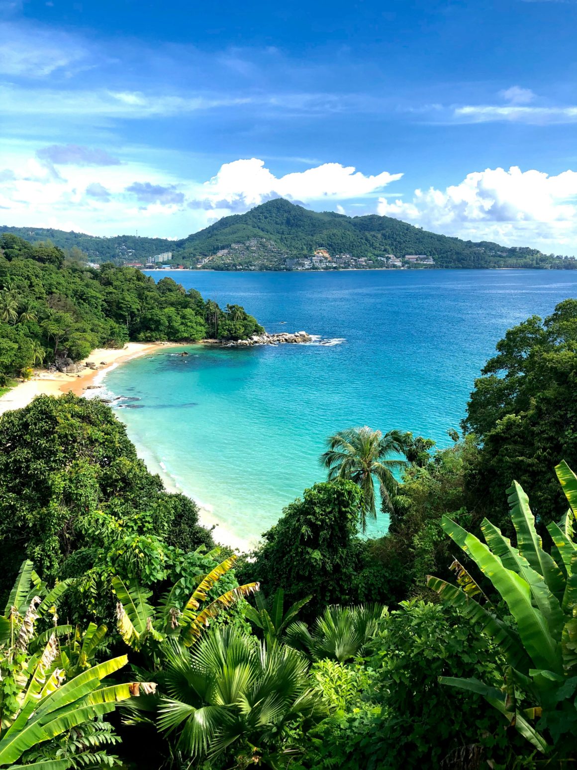 Tropical bay in Phuket with turquoise water and lush green hills