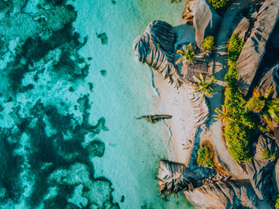 Aerial view of a tropical beach with granite rocks and turquoise lagoon