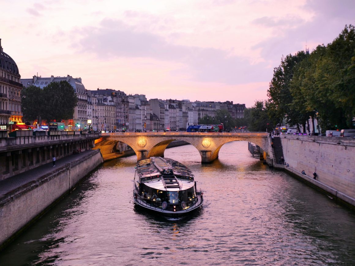 River cruise boat sailing on the Seine in Paris during twilight.