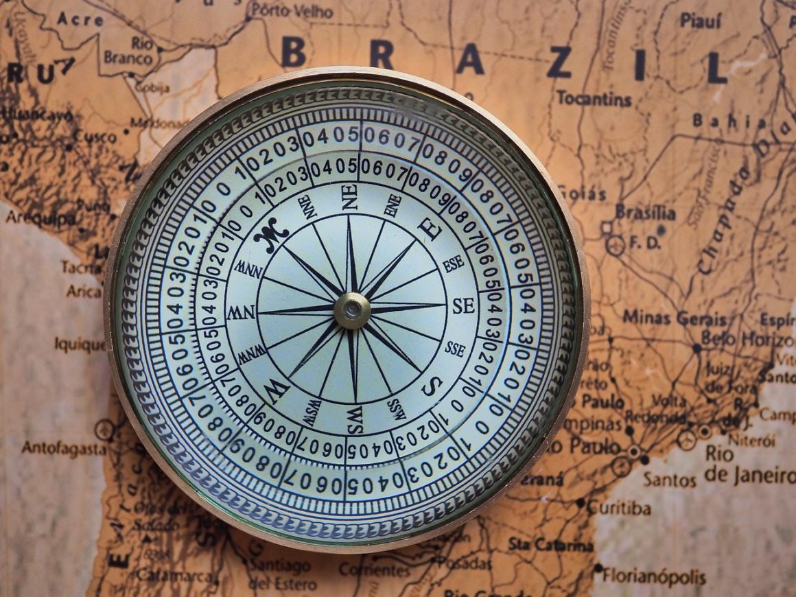 Marine compass placed on a world map, symbolizing navigation and geographic positioning at sea.