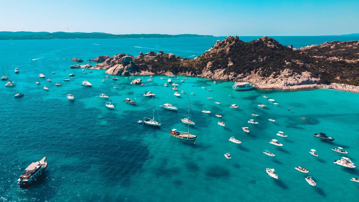 Boats anchored in the clear turquoise waters of Sardinia.