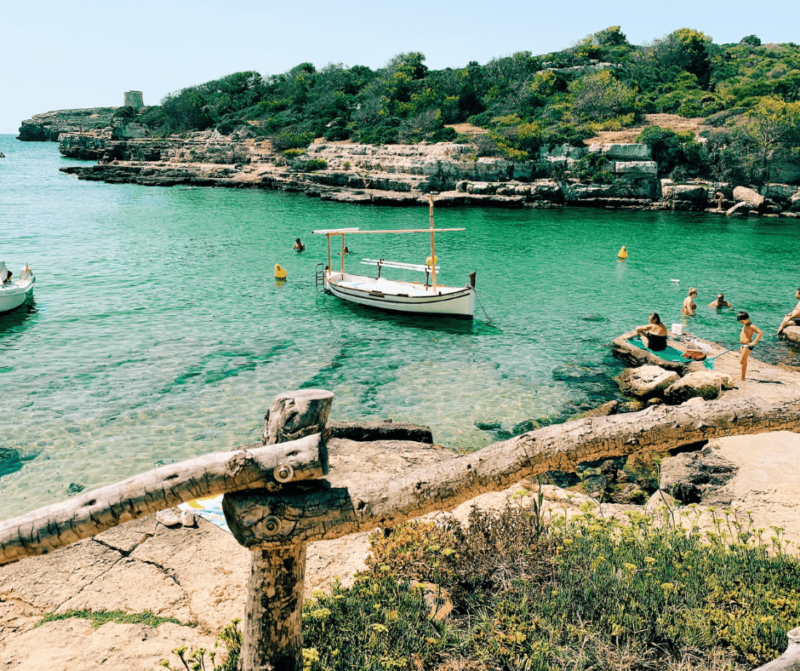 Barcos y bañistas en la cala de Alcaufar, en Menorca, las islas Baleares