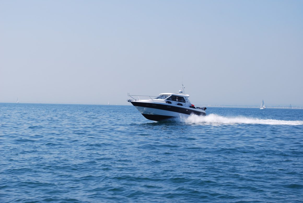 Barco a motor, más concretamente, una lancha, surcando las olas. 