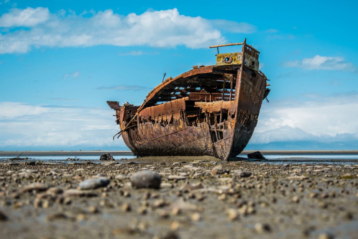 Barco en ruinas abandonado en la costa