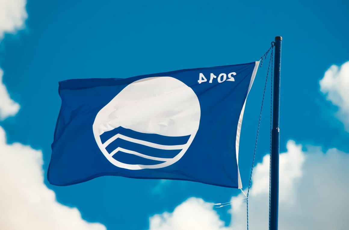 Bandera azul. Las playas y puertos deportivos que reciben la bandera azul son evaluadas en función de una serie de criterios relacionados con la calidad del agua, la limpieza y la seguridad, la gestión ambiental, los servicios y las instalaciones disponibles. 