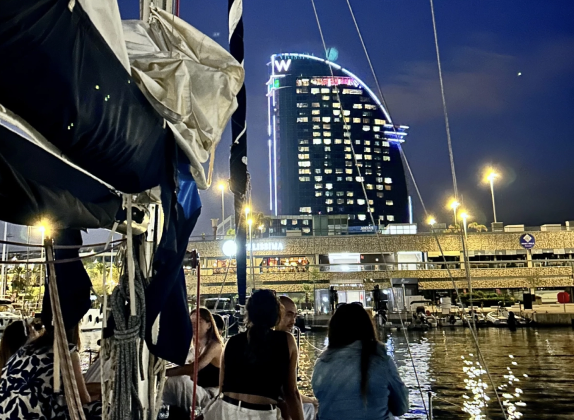 Barco de noche frente ciudad.