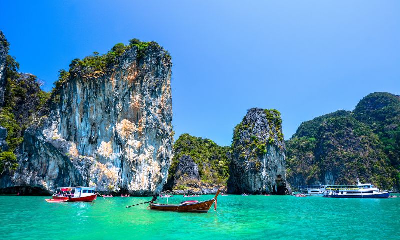Phuket destinazione 2023, mare cristallino, piccole barche, faraglioni