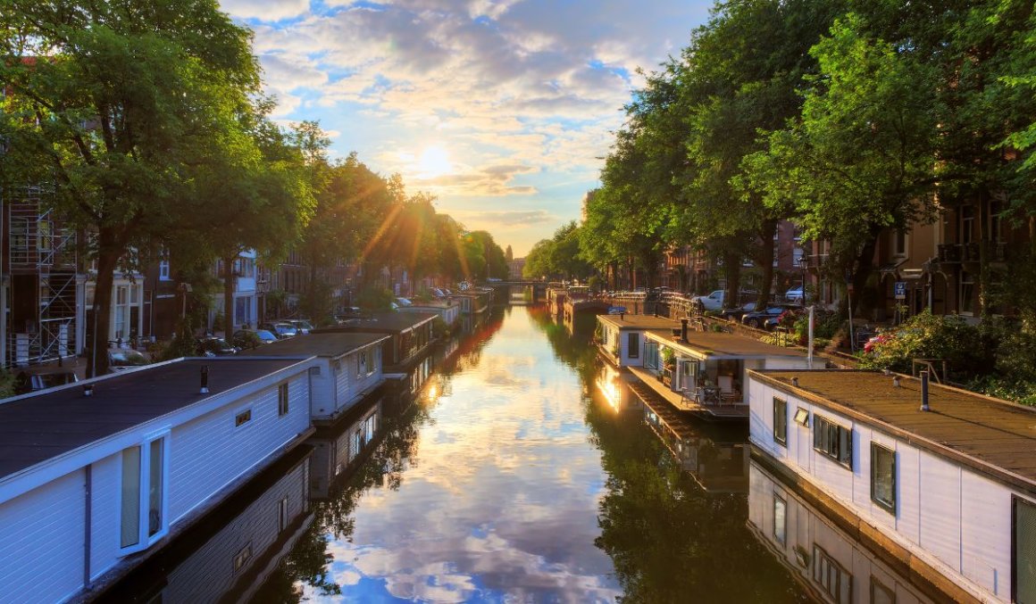 houseboat sul canale di Amsterdam, alberi verdi, tramonto