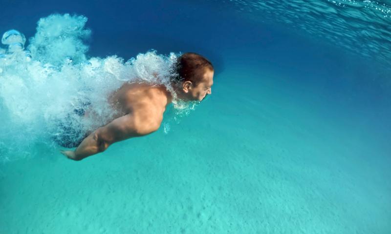 Uomo che nuota nel mare 